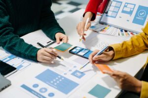 3 pessoas com canetas trabalhando em um projeto