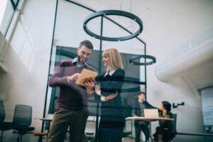 Homem e mulher em ambiente coorporativo e clima de descontração