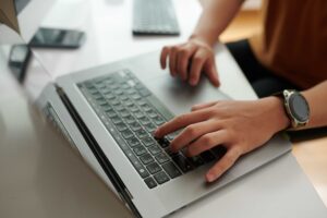 enquadramento de mãos de uma pessoa mexendo em um MAC