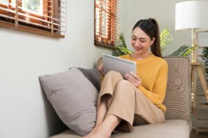 Mulher jovem sentada com tablet na mão